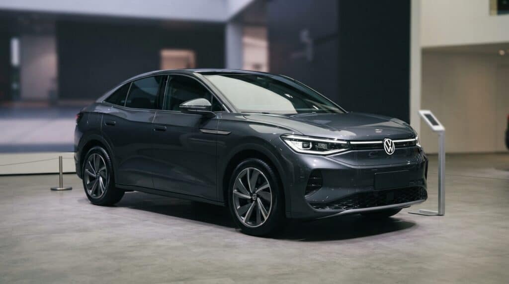 Parlak koyu gri renkli Volkswagen ID. Unyx 09 modeli bir araba, modern bir showroom içerisinde sergileniyor.