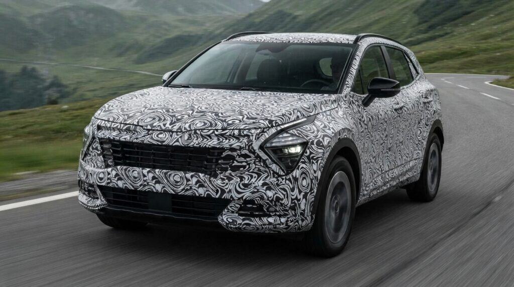 Kamufle edilmiş gövdeye sahip yeni nesil Kia Sportage, kıvrımlı dağ yolunda seyir halinde görünüyor.