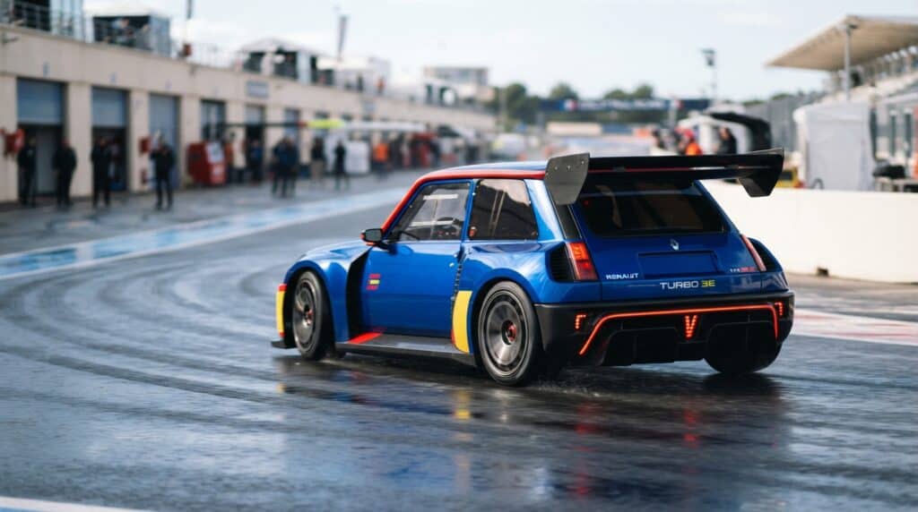 Islak pistte drift yapan mavi renkli Renault 5 Turbo 3E elektrikli yarış otomobili.