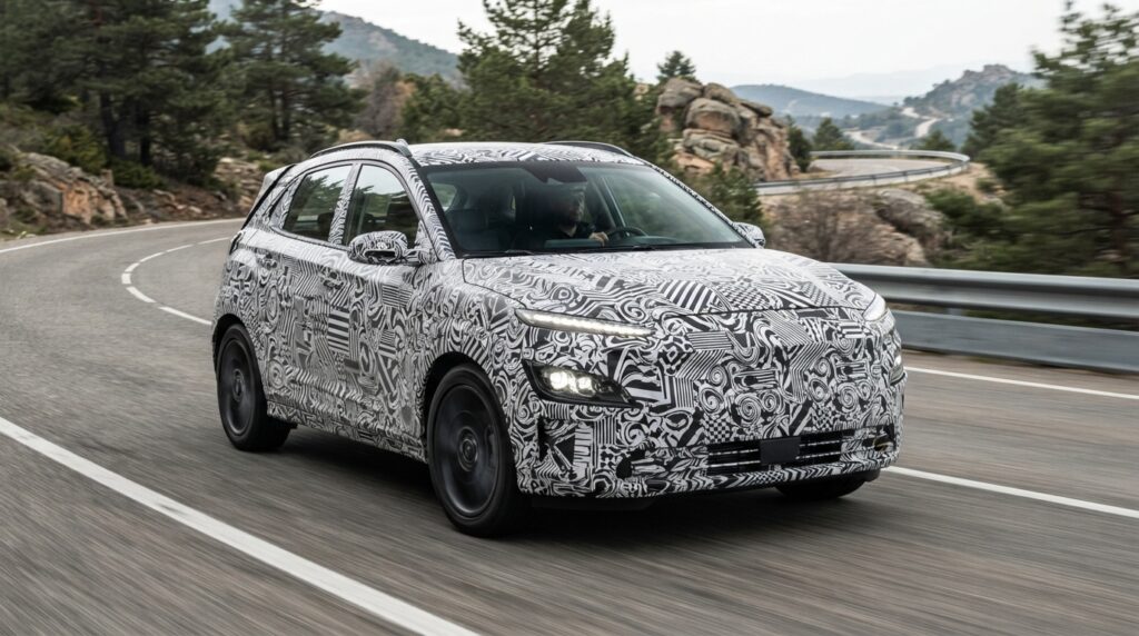 Kamuflajlı Hyundai prototip SUV, virajlı bir dağ yolunda seyrediyor.